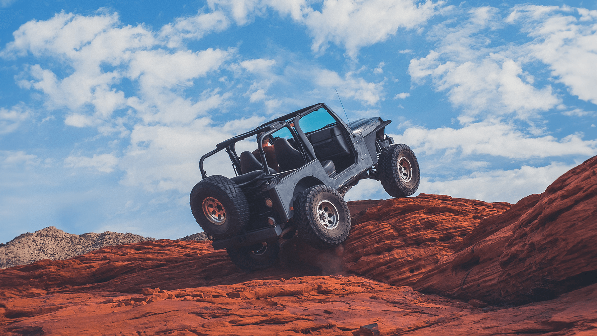 Jeep with lift going up rocky terrain